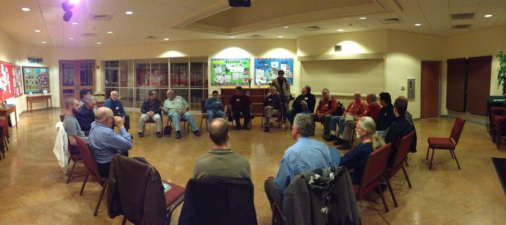 Men seated in a circle listening to one another